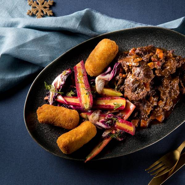 Saftiges Hirschgulasch mit bunten Möhren und Kroketten