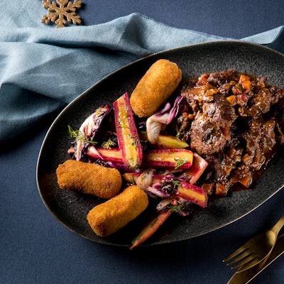 Saftiges Hirschgulasch mit bunten Möhren und Kroketten