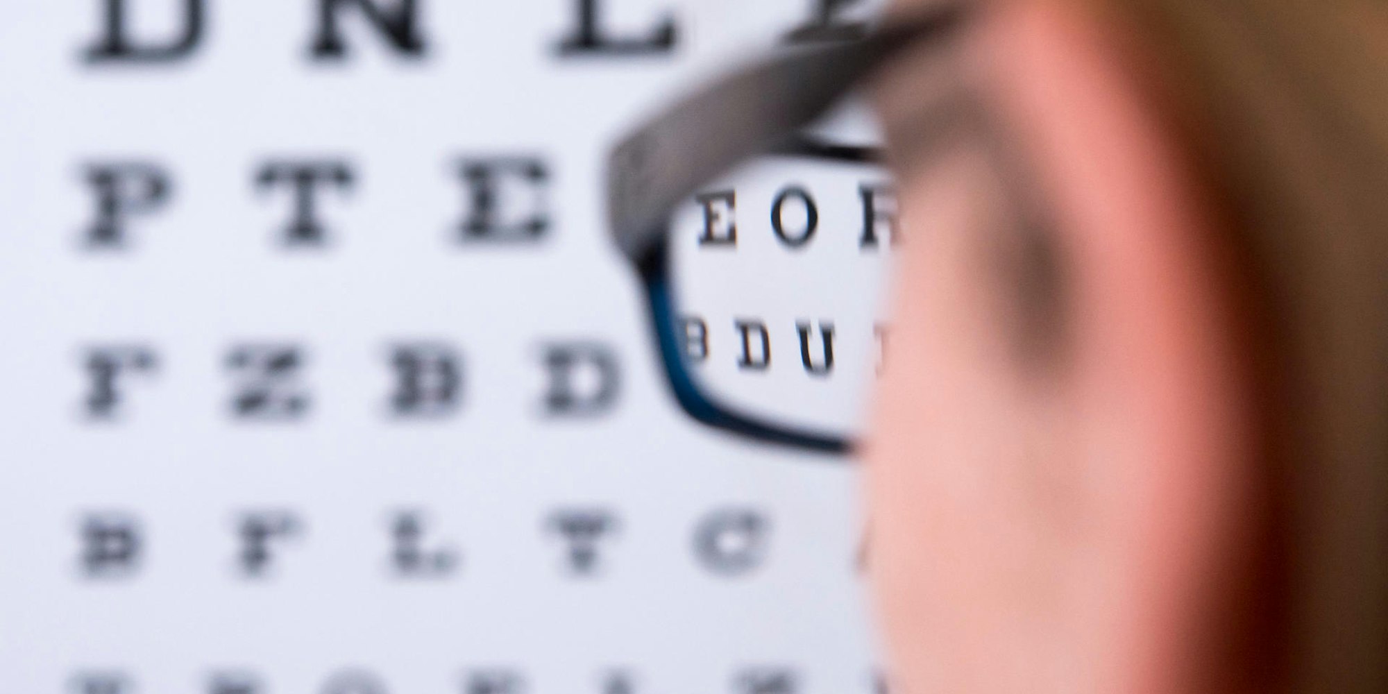 Symbolbild_Kurzsichtikeit_Mann_steht_vor_Buchstabentafel