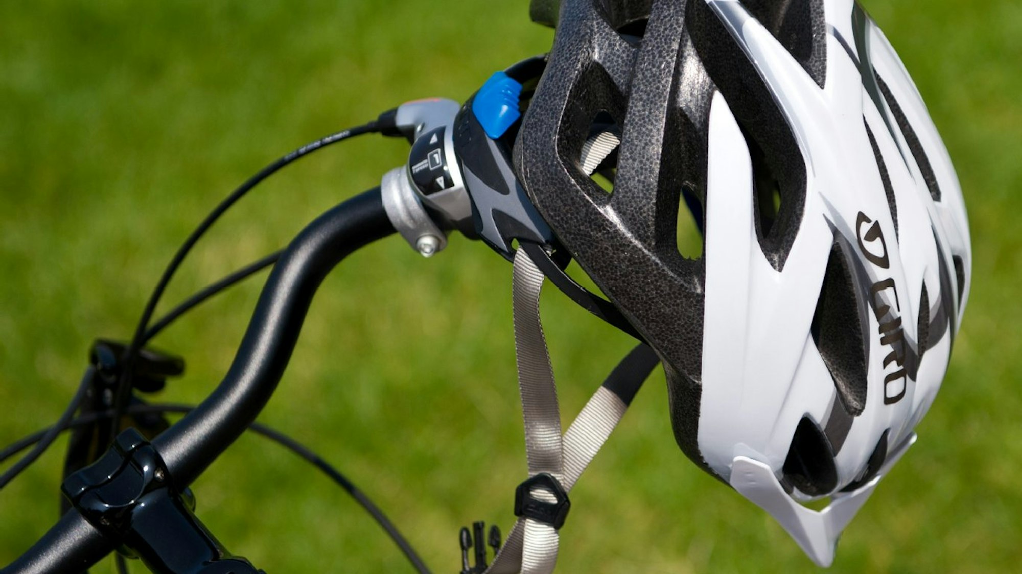 Das Bild zeigt einen Fahrradhelm an einem Lenker.