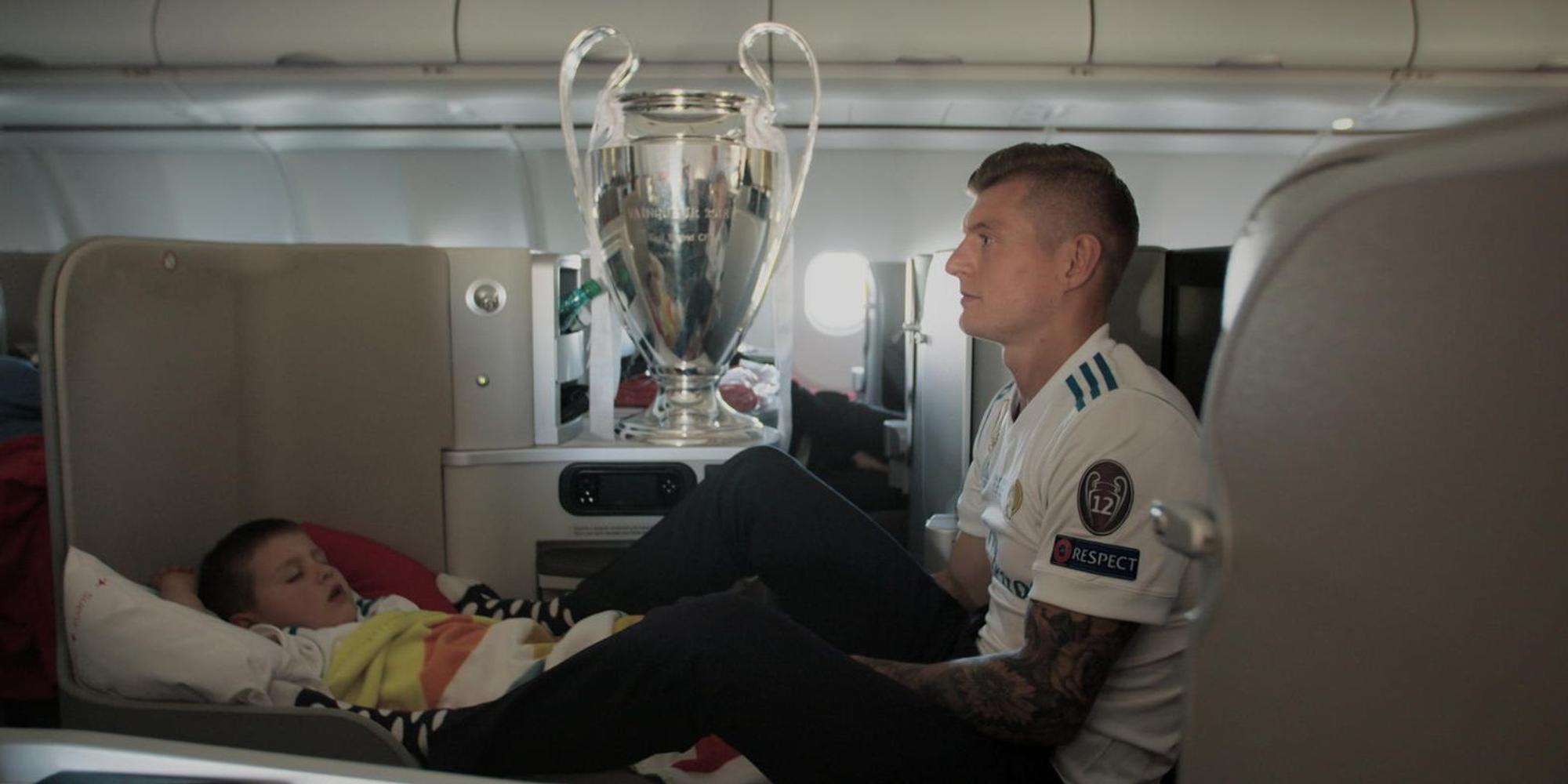 Toni_Kroos_mit_Pokal_und_Sohn_auf_dem_Heimflug_vom_Champ