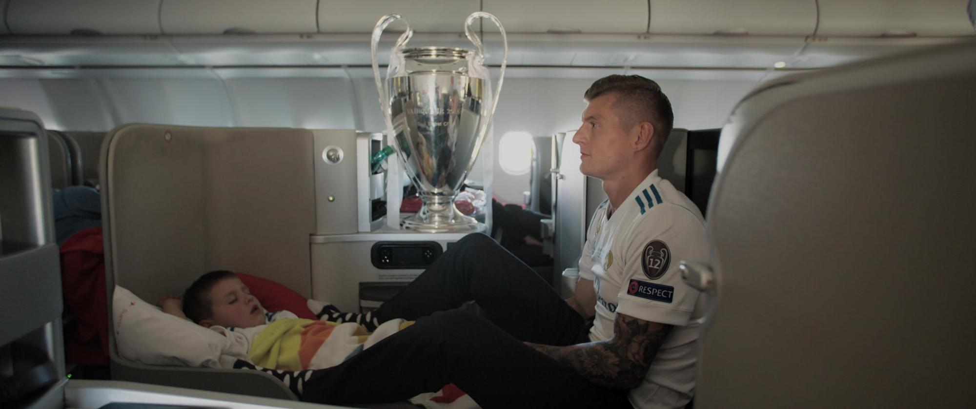 Toni_Kroos_mit_Pokal_und_Sohn_auf_dem_Heimflug_vom_Champ