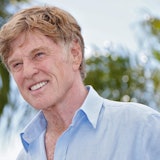 Robert Redford lacht für Fotografen.