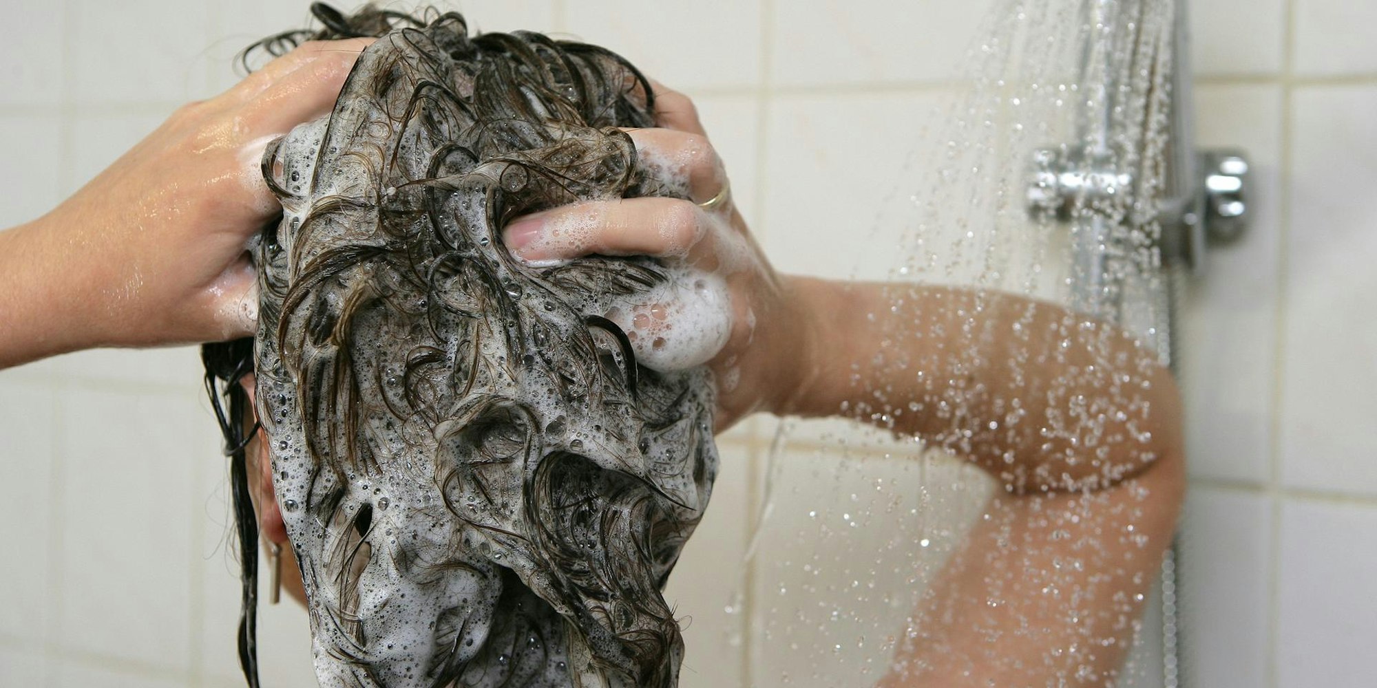 Frau wäscht sich die Haare
