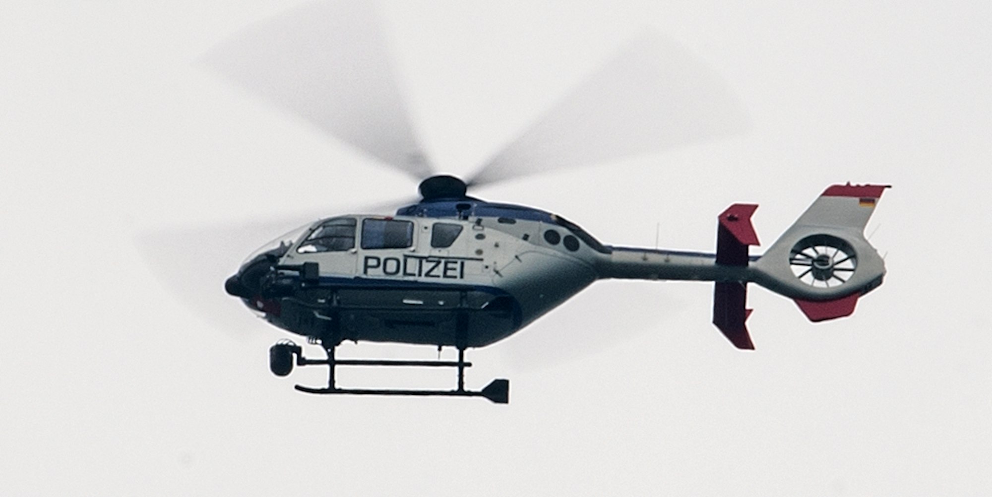 Polizeihubschrauber bei grauem Himmel Symbolbild dpa