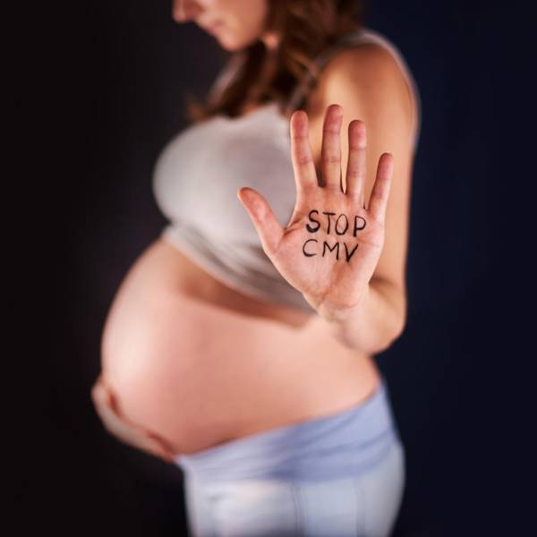 Hand einer Schwangeren mit dem Schriftzug "Stopp CMV"