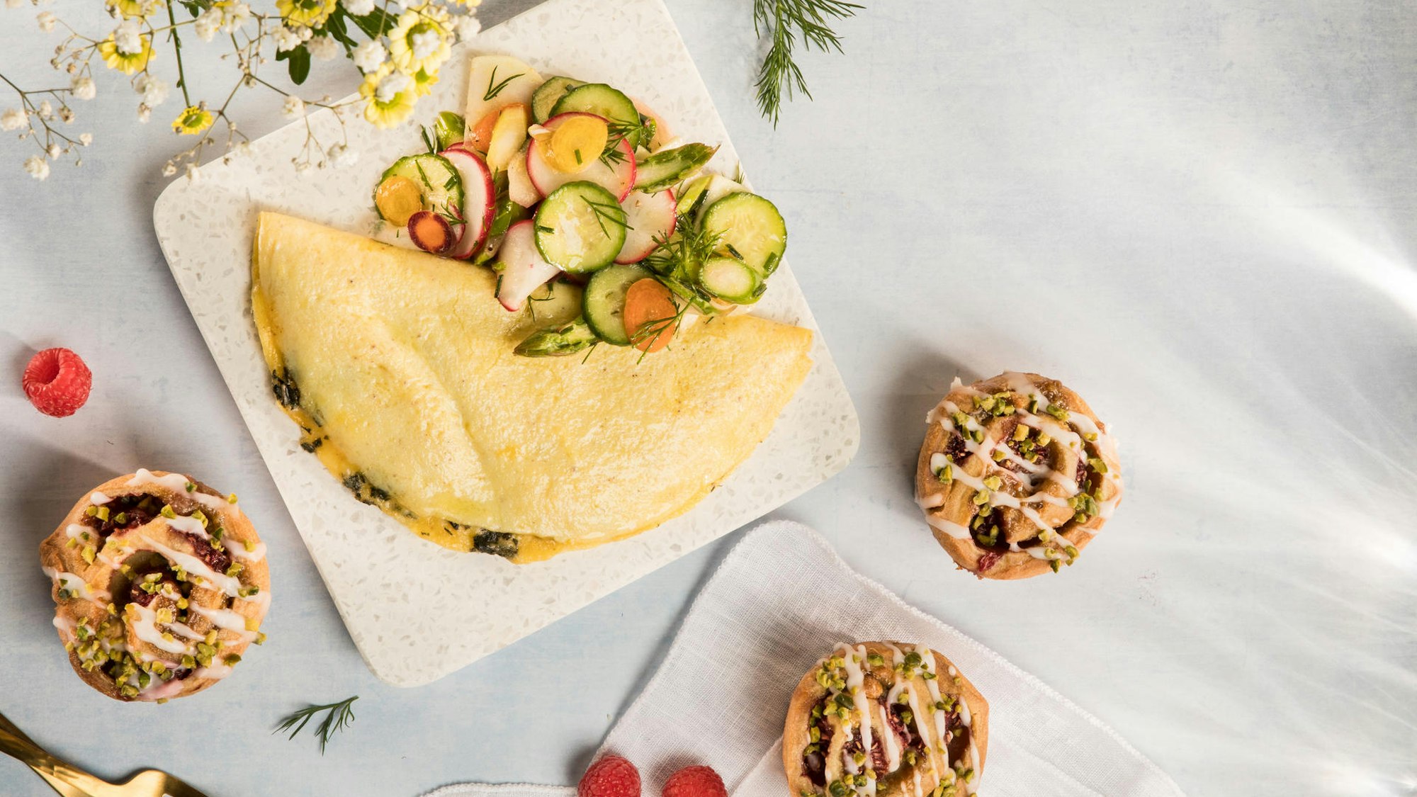 Ein lecker angerichtetes Omelette und Pistazienschnecken liegen angerichtet auf einer Platte