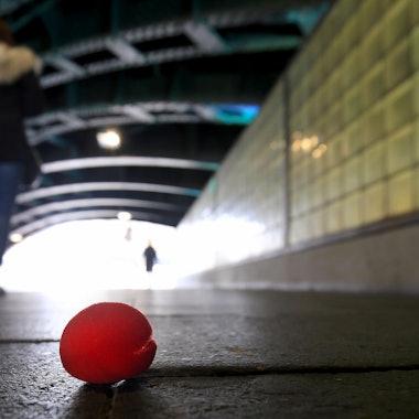 Eine Pappnase liegt einsam auf der Straße.
