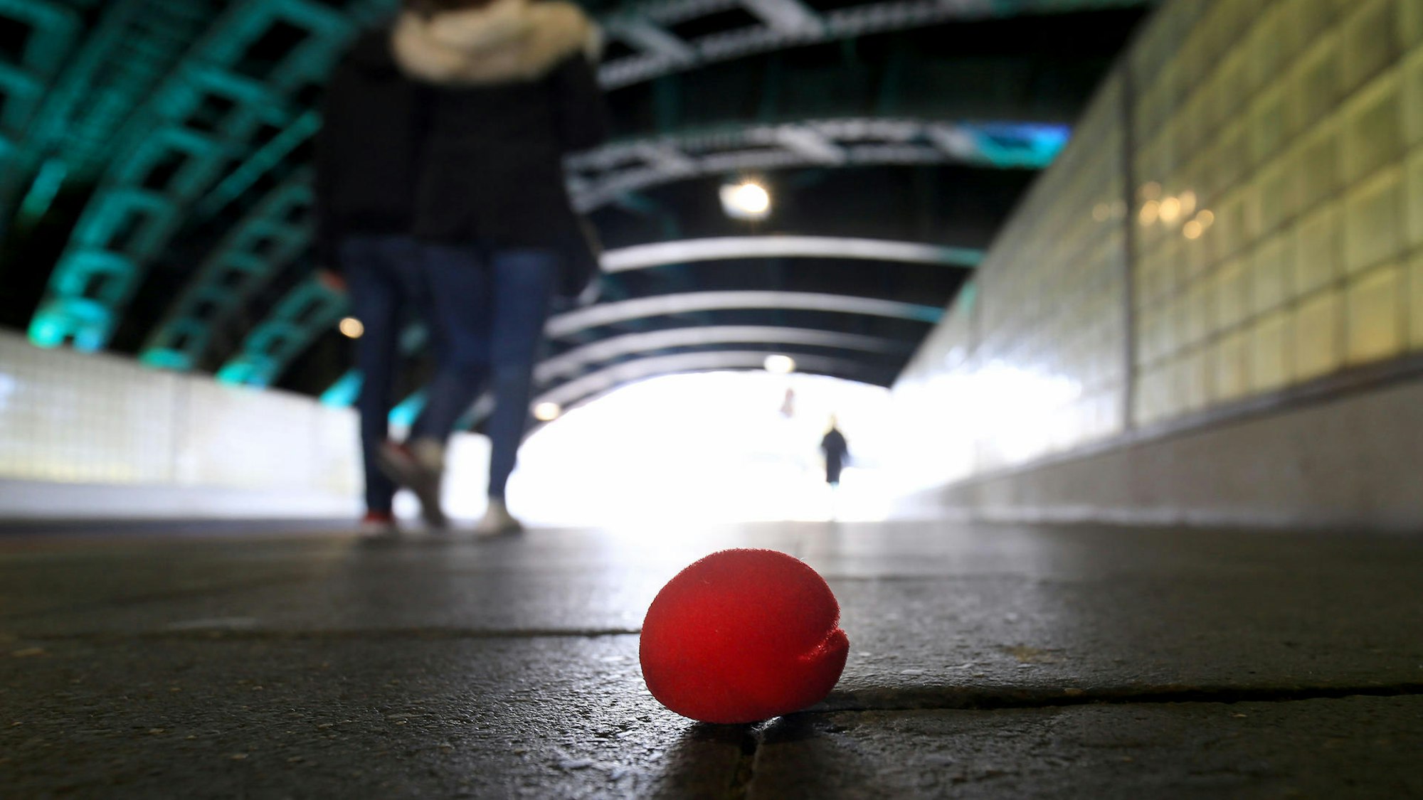 Eine Pappnase liegt einsam auf der Straße.