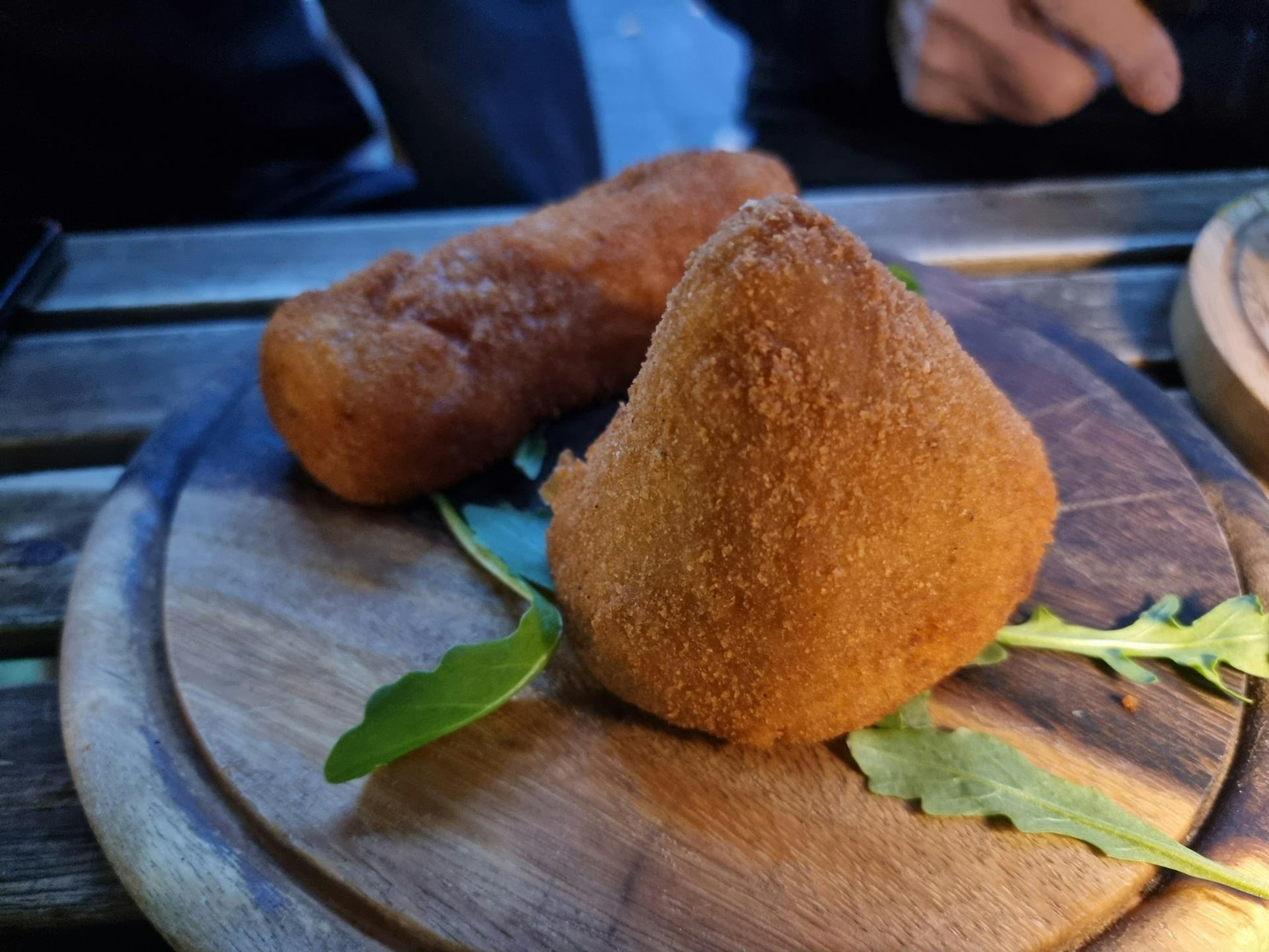 , Arancini und Crocchette di Patate (zusammen auf einem Holzbrett)