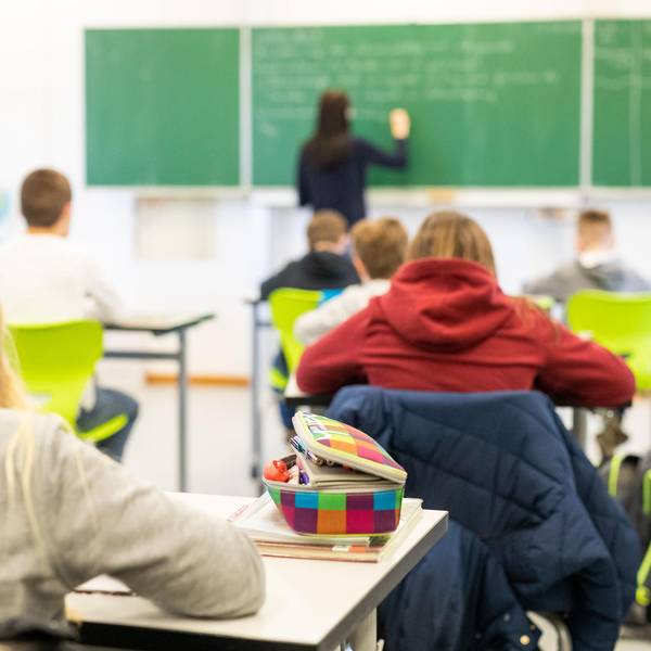 In einem Klassenzimmer stehen Stühle auf Tischen.