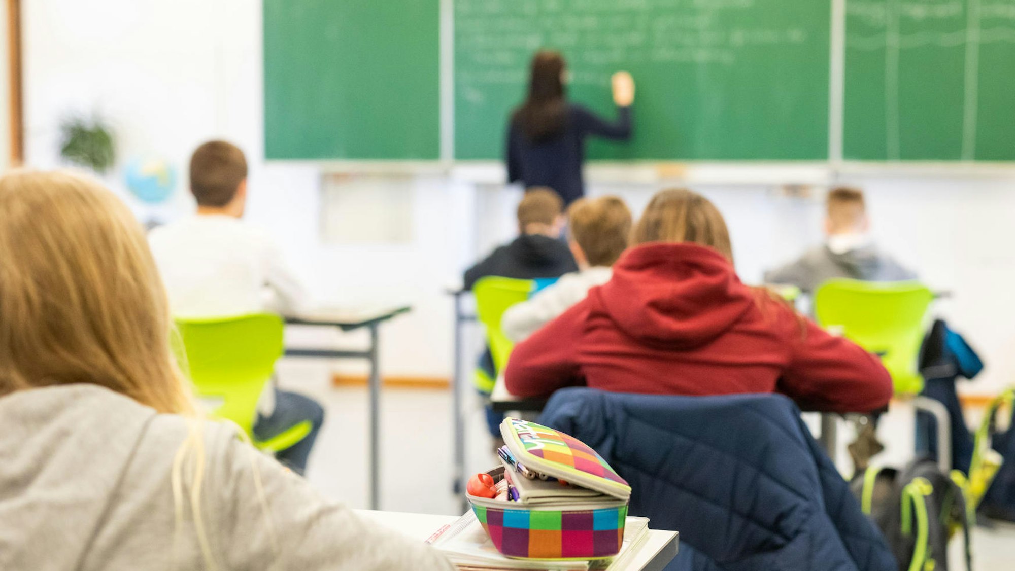 In einem Klassenzimmer stehen Stühle auf Tischen.