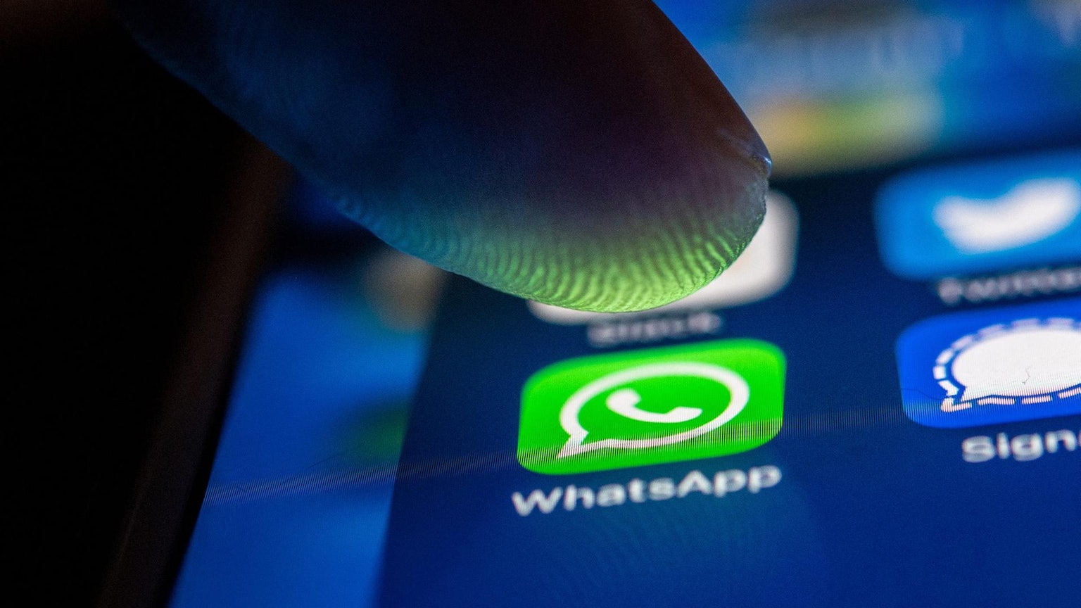 Eine Person tippt auf einem Smartphone auf das WhatsApp-Symbol.