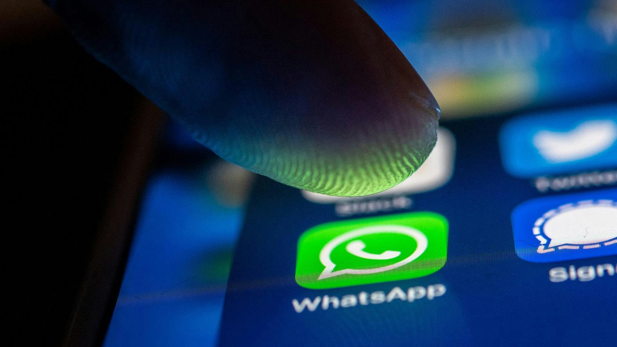 Eine Person tippt auf einem Smartphone auf das WhatsApp-Symbol.