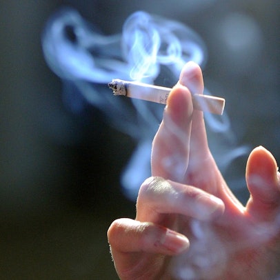 Hand_hält_eine_qualmende_Zigarette